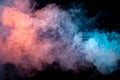 Multicolored smoke from a vape of blue and purple color of the exhaled by a pillar on a black isolated background. Bright clouds Royalty Free Stock Photo