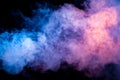 Multicolored smoke from a vape of blue and purple color of the strange mystical form on on a black isolated background. Bright Royalty Free Stock Photo