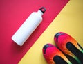 Multicolored sneakers water bottle on yellow-red background