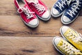 Multicolored sneakers on wooden floor.