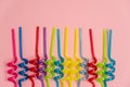 Multicolored spiral straws on pink background, flat lay Royalty Free Stock Photo