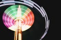 Multicolored Star Flyer tall Carousel rotating on long chains in an amusement park. Entertainment and leisure activities concept