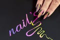 Multicolored striped nail design on long sharp shape with black lacquer. Royalty Free Stock Photo