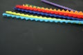 Multicolored strips of felt on a black background