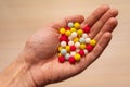 Multicolored sugar tablets in the palm. Candy in the form of balls of different colors in hand Royalty Free Stock Photo