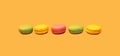 Multicolored sweet macaroons on yellow background