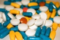 Multicolored tablets and capsules piled with a slide