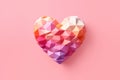 Multicolored three-dimensional heart in pastel colors on pink background with copyspace