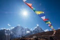 Multicolored Tibetan prayer flags with mantras flapping on the wind with High Himalayas range background. Taboche 6495m and