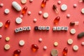 Multicolored title SAVE YOUR LIFE from white and black cubes on the table with tablets on coral background.