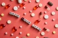 Multicolored title SAVE YOUR LIFE from white and black cubes on the table with tablets on coral background