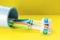 Multicolored toothbrushes in a blue glass on a yellow background. Close up Royalty Free Stock Photo