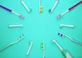 Multicolored toothbrushes on a turquoise background with copy space