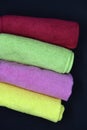 Multicolored towels on a black background. Terry towels. Colored rags in rolls. Rolled-up rags Royalty Free Stock Photo