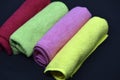 Multicolored towels on a black background. Terry towels. Colored rags in rolls. Rolled-up rags Royalty Free Stock Photo