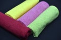 Multicolored towels on a black background. Terry towels. Colored rags in rolls. Rolled-up rags Royalty Free Stock Photo