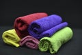 Multicolored towels on a black background. Terry towels. Colored rags in rolls. Rolled-up rags Royalty Free Stock Photo