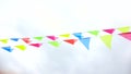 Multicolored triangular flags hang on a string and flutter in the wind against a cloudy cloudy sky Royalty Free Stock Photo