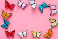 Multicolored tropical butterflies on pink background top-down frame copy space