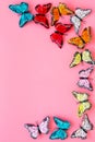 Multicolored tropical butterflies on pink background top-down frame copy space