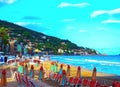 Multicolored umbrellas on the beach in Alassio, province of Savona, Sanremo region, Italy. City at sunset