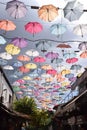 Multicolored umbrellas hang from the top between the streets to protect from the sun.