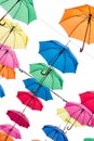 Multicolored umbrellas are suspended on a white cloudy sky background Royalty Free Stock Photo