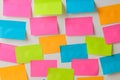 Multicolored various notes or sticky post-it on a white wall. Royalty Free Stock Photo
