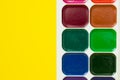 Multicolored watercolor paints for painting on yellow background Royalty Free Stock Photo