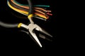 Multicolored wires and round nose pliers on black isolated background Royalty Free Stock Photo