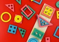 Multicolored wooden blocks on a red background. Trendy puzzle toys. Geometric shapes: square, circle, triangle, rectangle. Royalty Free Stock Photo