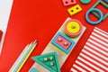 Multicolored wooden blocks on a red background. Trendy puzzle toys. Geometric shapes: square, circle, triangle, rectangle. Royalty Free Stock Photo