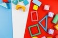 Multicolored wooden blocks on red blue background. Trendy puzzle toys. Geometric shapes: square, circle, triangle, rectangle. Royalty Free Stock Photo