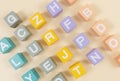 Multicolored wooden cubes with the alphabet on the beige table. Trendy puzzle toys. Geometric shapes. Back to school.