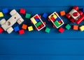 Multicolored wooden toys cubes, pyramid and cars on classic blue background. Set colorful toys for games in kindergarten, Royalty Free Stock Photo