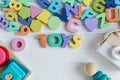 Multicolored wooden toys cubes, pyramid, letters, numbers on white wooden background. Set colorful toys for games in kindergarten Royalty Free Stock Photo