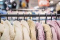 Multicolored youth faux fur coats on clothes rack in shop, assortment in clothing store. Shopping concept Royalty Free Stock Photo