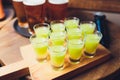 Multicolour alcoholic shots on wooden tray in nightclub. Royalty Free Stock Photo