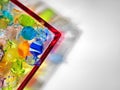 Multicoloured glass sweets in dish, studio shot