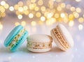 multicoloured macarons with cream on white surface, golden bokeh effect behind Royalty Free Stock Photo