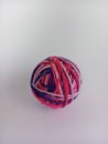 Multicoloured pink ball of yarn on a white background