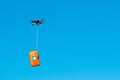 Multicopter drone flying with a first aid kit isolated on a blue sky, emergency medical care concept