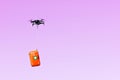 Multicopter drone flying with a first aid kit isolated on a pink background, emergency medical care concept