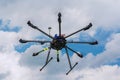 Multicopter in flight on sky and clouds background