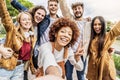 Multicultural best friends having fun taking group selfie portrait outside - Smiling guys and girls celebrating party Royalty Free Stock Photo