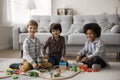 Multicultural boys looking at camera distracted from playing construction set Royalty Free Stock Photo