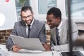 multicultural business partners reading document and smiling