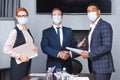 Multicultural businessmen in medical masks shaking Royalty Free Stock Photo