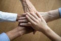 Multicultural employees stacking hands together engaged in team building