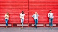 Multicultural friends group using smartphone by red wooden background - Technology and urban lifestyle concept